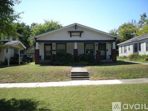A house with a front yard and a porch is for sale.