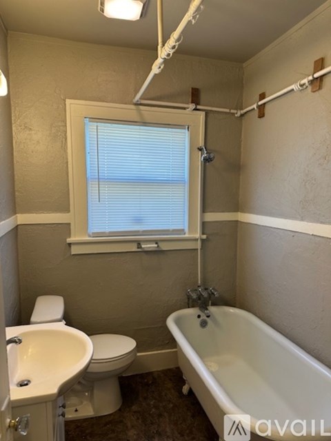 A bathroom with a toilet, sink, and bathtub.