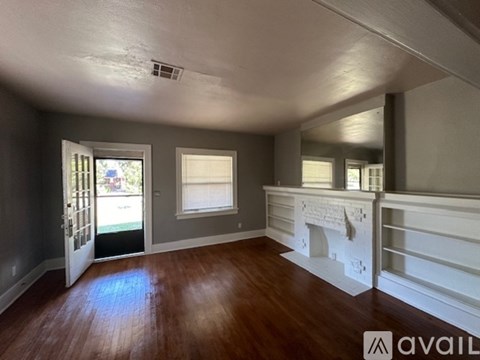 A room with wooden floors and a fireplace.
