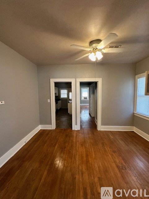 A room with wooden floors and a ceiling fan.