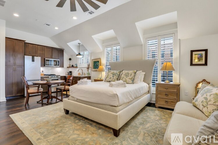 A bedroom with a large bed and a ceiling fan.
