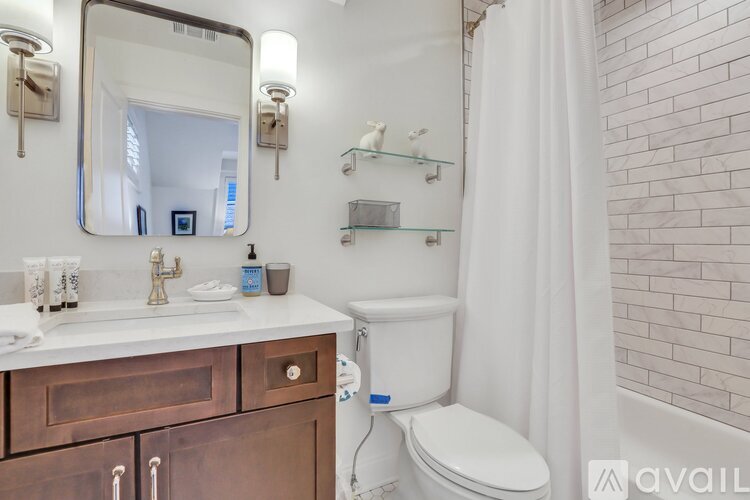 A bathroom with a toilet, sink, and mirror.