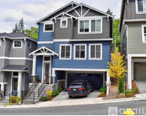 A blue house with a car parked in the driveway.