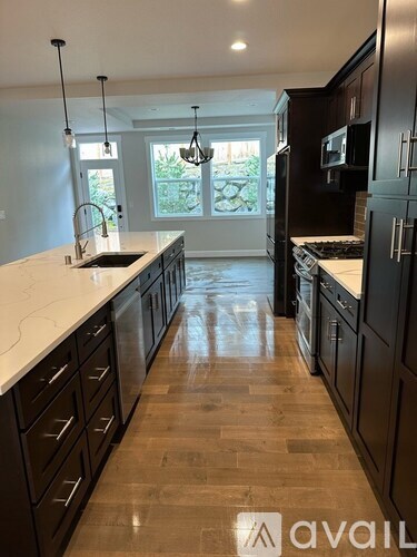 A kitchen with dark wood cabinets and a white countertop.