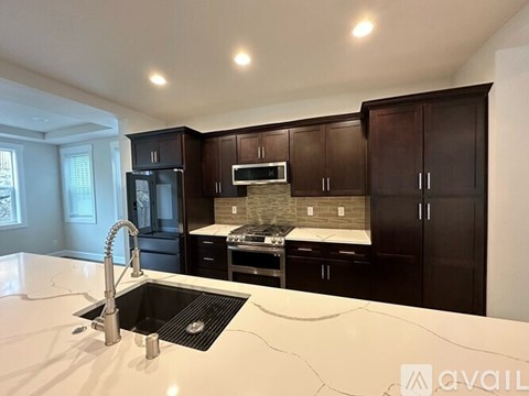A kitchen with a black countertop and white sink.