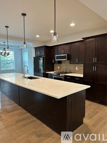 A kitchen with dark brown cabinets and a white countertop.