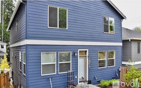 A blue house with a white door and windows.