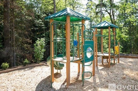 A playground with a green canopy and a slide.