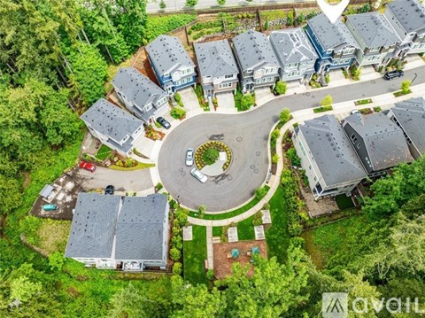 A bird's eye view of a residential area with houses and a central roundabout.