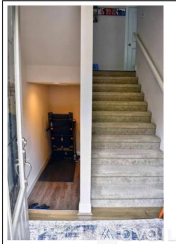 A staircase with a carpeted runner and a wooden handrail.