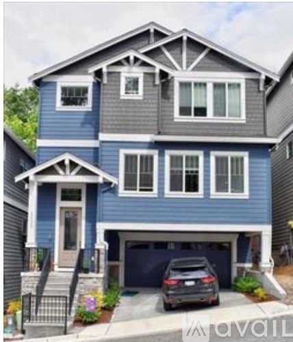 A two-story house with a blue exterior and a garage.