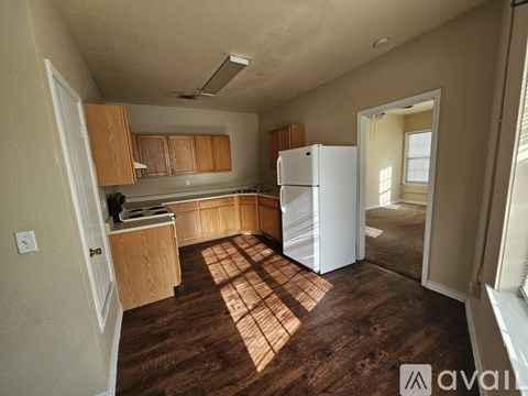 A kitchen with wooden cabinets and a white refrigerator.