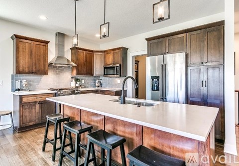 A kitchen with a white counter top and wooden cabinets.