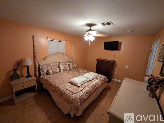 A bedroom with a bed, nightstand, and a lamp.