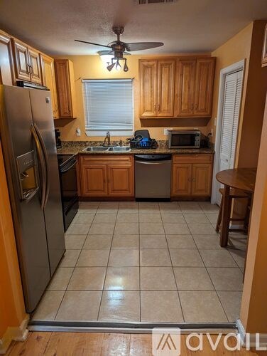 A kitchen with wooden cabinets and a tile floor.