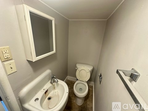 A bathroom with a toilet, sink, and mirror.