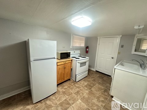 A kitchen with a white refrigerator, a white sink, and a white stove.