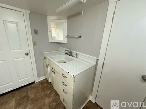 A white bathroom with a sink and a mirror.