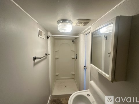 A bathroom with a toilet, sink, and shower.