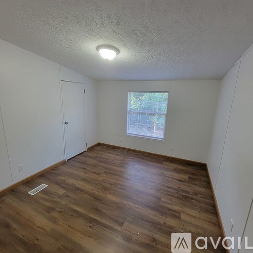 A room with wooden flooring and a window.