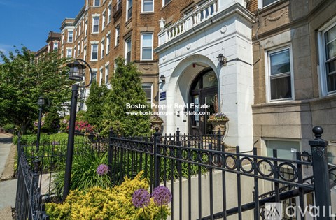 A black iron fence surrounds a building entrance.