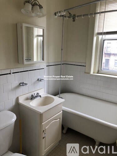 A white bathroom with a tub, sink, and toilet.