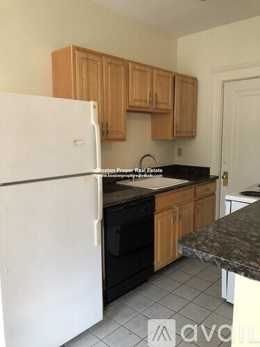 A kitchen with a white fridge and wooden cabinets.