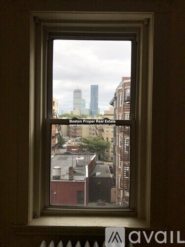 A window with a view of a cityscape in the background.