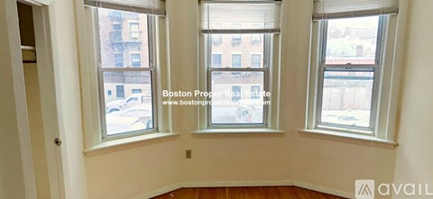 Three windows in a room with white walls and wooden floors.