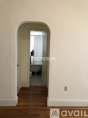 A room with a doorway leading to a bathroom.