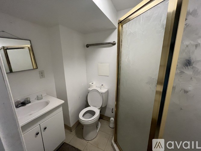 A bathroom with a toilet, sink, and mirror.