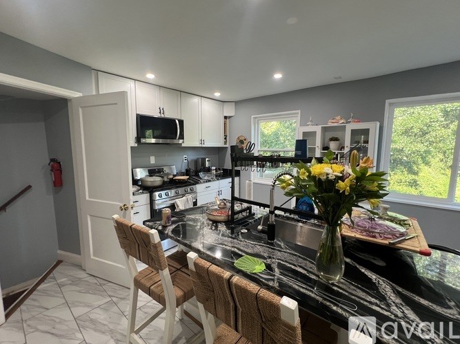 A kitchen with a black countertop and white cabinets.
