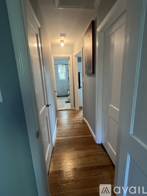 A long hallway with white doors and a light on the wall.