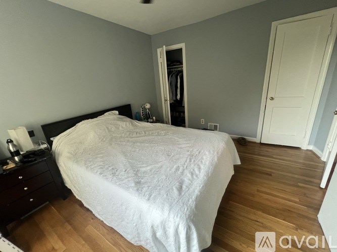 A bedroom with a large bed and a wooden floor.