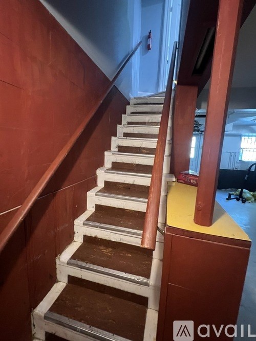 A staircase with a red wall on the left and a yellow baseboard.