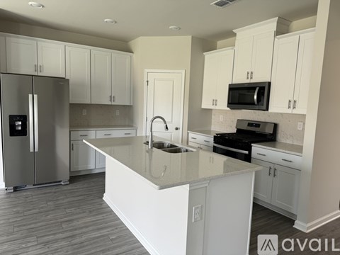 A kitchen with white cabinets and a granite countertop.