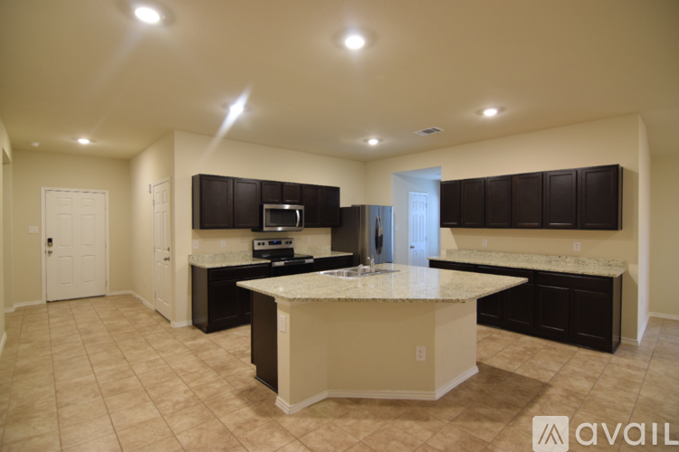 A spacious room with beige carpeting and a white door.