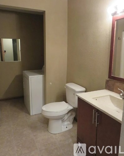 A bathroom with a toilet, sink, and mirror.
