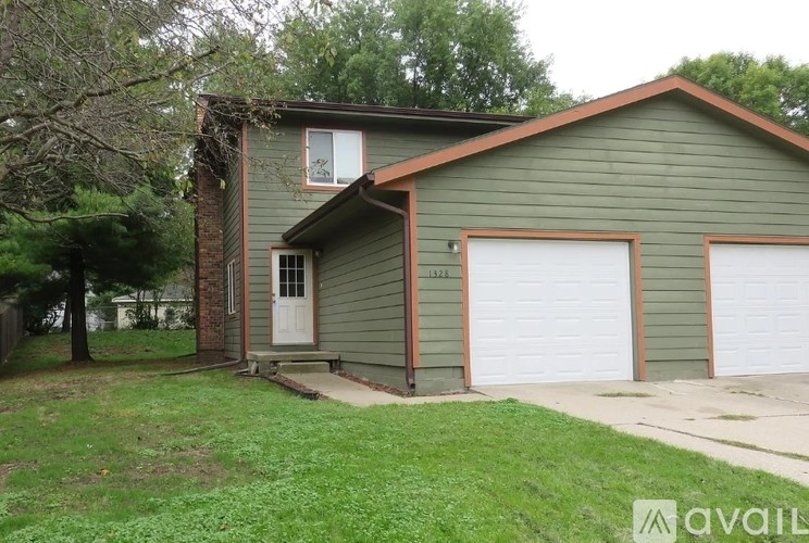 A house with a green exterior and a white garage door.