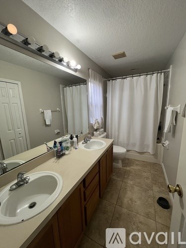 A bathroom with two sinks and a shower curtain.