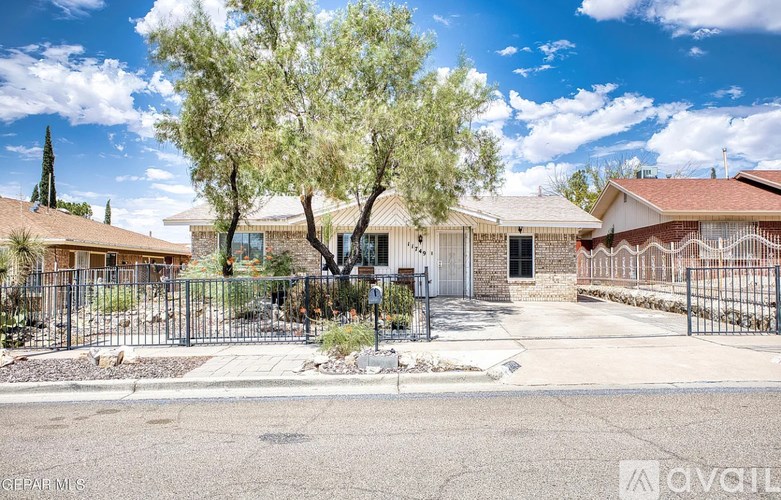 A residential area with houses and a tree in the foreground.
