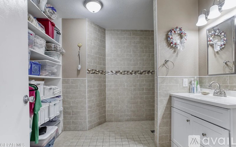 A bathroom with a white sink and a shower with a glass door.