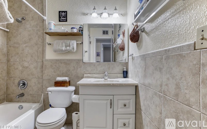 A bathroom with a white toilet, sink, and bathtub.