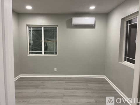 A room with a window and a wall-mounted air conditioner unit.