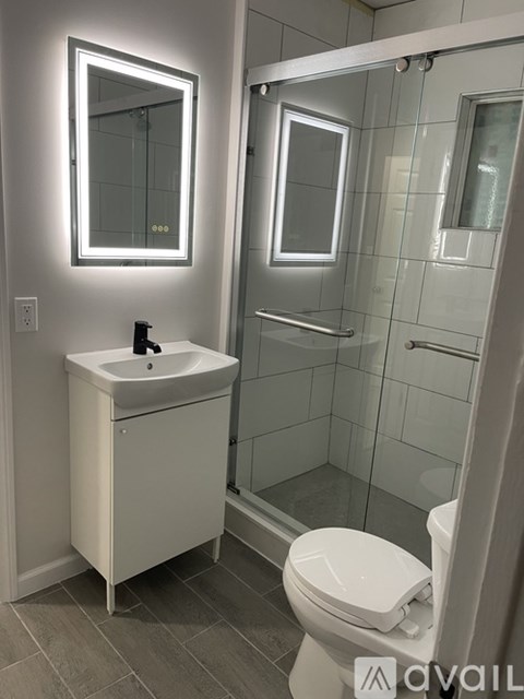 A white sink and toilet in a modern bathroom.