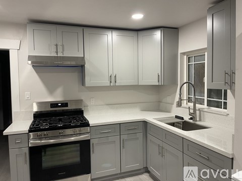 A modern kitchen with a stove, sink, and cabinets.