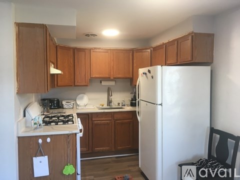 A kitchen with wooden cabinets and a white refrigerator.