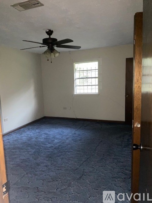 A room with a ceiling fan and a window.