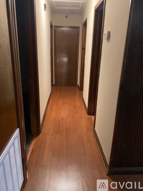 A long hallway with wood floors and white walls.