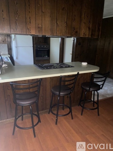A kitchen with a table and two chairs.